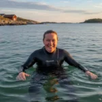 Upplev västkustens pärla Strömstad Glad person i våtdräkt i vattnet utanför Strömstad.